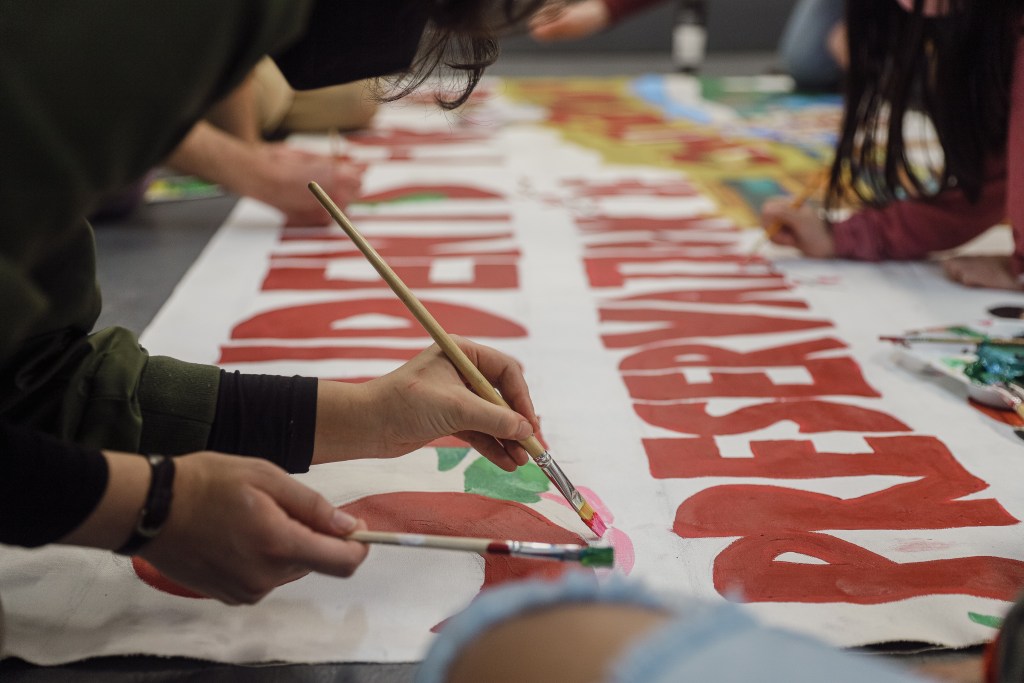 Volunteers paint No Arena banners
